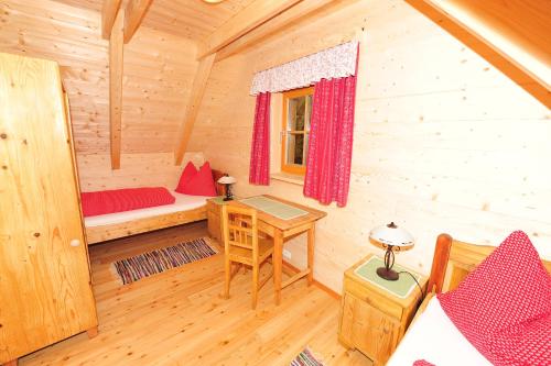a room with a bed and a desk in a cabin at Holzmeisterhütte Teichalm-Sommeralm in Sankt Kathrein am Offenegg