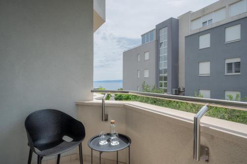a balcony with a black chair and a table at Adriatic Queen Residence in Split
