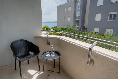 a balcony with two chairs and a table with wine glasses at Adriatic Queen Residence in Split