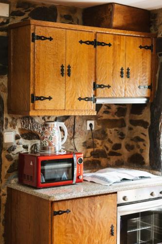 a red microwave sitting on a counter in a kitchen at Quinta da Malhada in Cabril