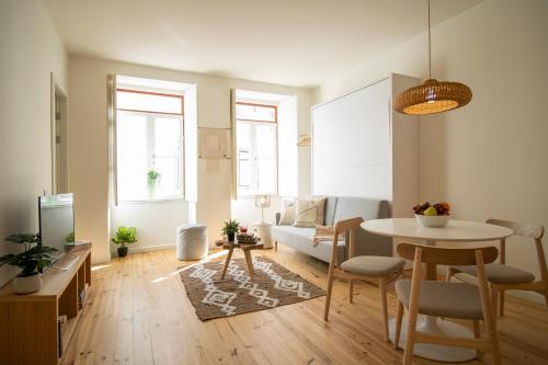 a living room with a table and a dining room at Casas do Pátio in Coimbra