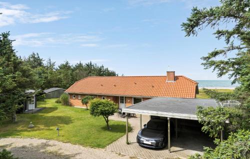 une voiture garée dans l'allée d'une maison dans l'établissement 4 Bedroom Beach Front Home In Thyholm, à Thyholm