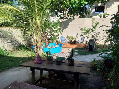 two people sitting in a blue chair in a yard at Casinha rustica em Monte Alto in Arraial do Cabo
