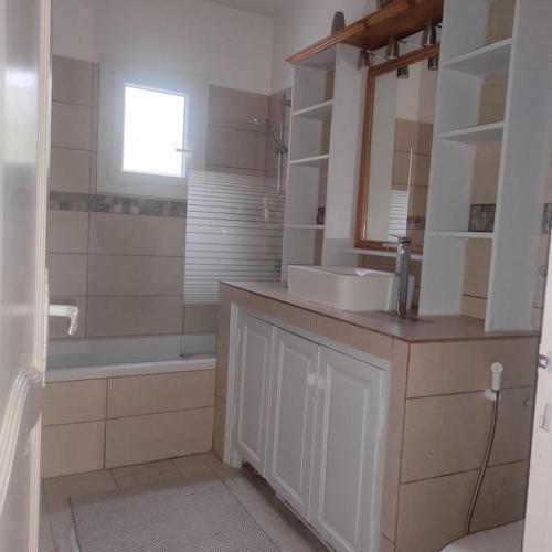 une salle de bain avec un lavabo, une baignoire et un miroir dans l'établissement Villa Romaquenti, Trans en Provence 137m2, 5 lits double, 10 personnes, piscine, terrain pétanque, jeu de fléchettes, à Trans-en-Provence