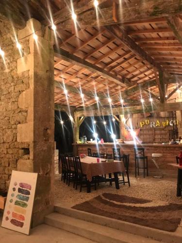 une salle à manger avec une table, des chaises et des lumières dans l'établissement La Cabane, à Prailles