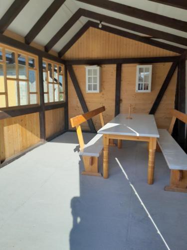 a large room with a picnic table and a bench at Кукул in Vorokhta