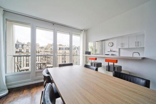 Cette grande chambre dispose d'une table et d'une grande fenêtre. dans l'établissement Eiffel, à Paris