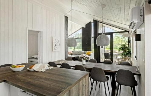 a kitchen and dining room with a table and chairs at Cozy Home In Væggerløse With Wifi in Marielyst