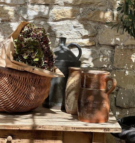 a table with two vases and a basket of flowers at Le Numéro 10 in Bernis