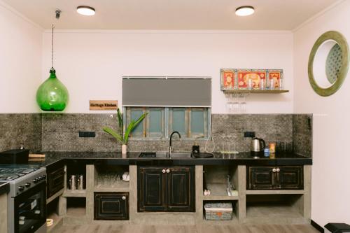 a kitchen with black cabinets and a sink at Still Waters Artistry in Negombo