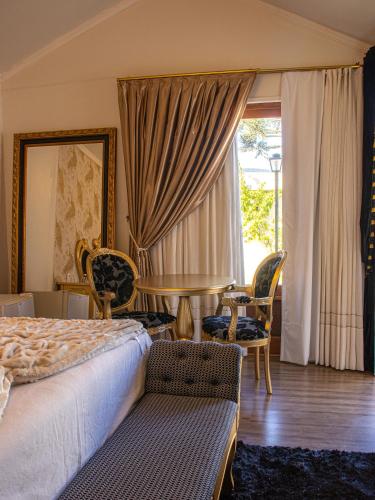 a bedroom with a bed and a table and chairs at Pousada Dom Pietro in Urubici
