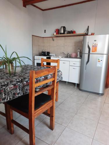 une cuisine avec une table et un réfrigérateur dans l'établissement Alojamiento por día, à Puerto San Julian