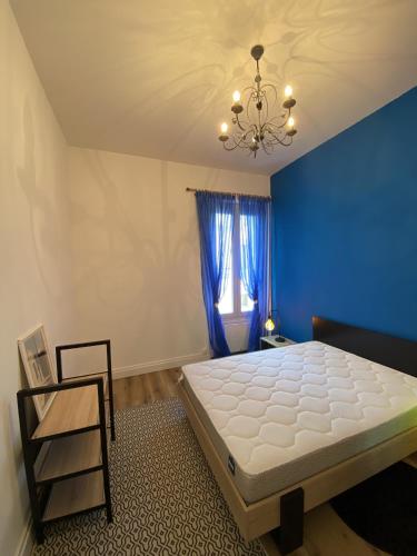 une chambre avec un grand lit et un mur bleu dans l'établissement Appartement renove apercu mer remblai, à Les Sables-dʼOlonne