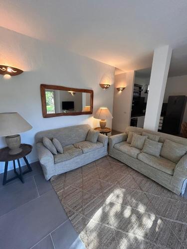 a living room with two couches and a mirror at Le Case Di Capriccioli in Porto Cervo