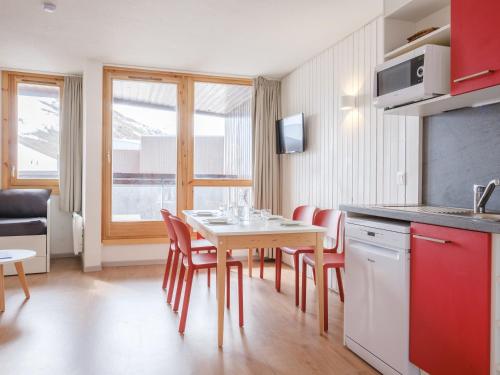 a kitchen and dining room with a table and chairs at travelski home select - Résidence Les Lys in Les Menuires