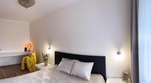a bedroom with a bed with a black headboard at Apartament Amber 3 in Liepāja