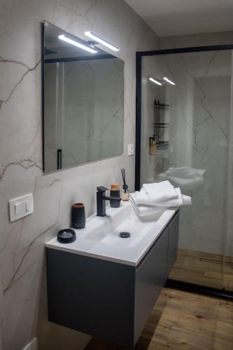 a bathroom with a white sink and a mirror at AMarescaladeiturchy Scaladeiturch in Realmonte