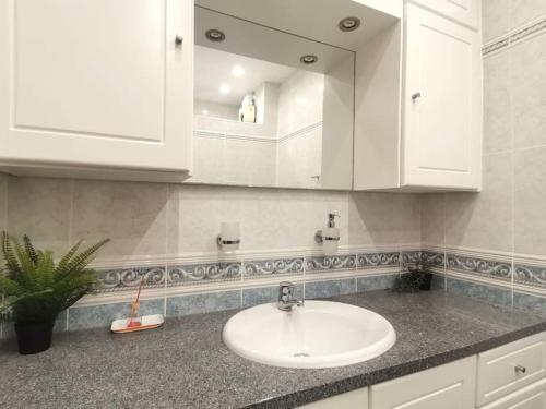 a bathroom with a sink and a mirror at Mountain View Beach House in Costa da Caparica