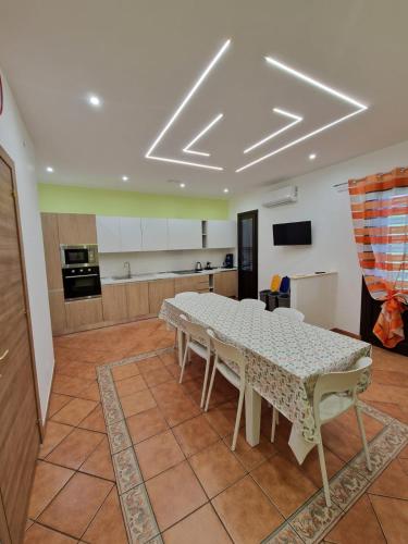 a dining room with a table and a kitchen at Casa Vera in Piana degli Albanesi