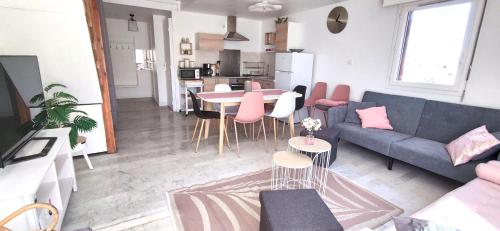 un salon avec un canapé, une table et des chaises dans l'établissement L'appartement de la chance, au Cap d'Agde
