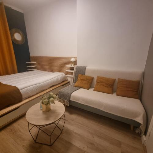 une chambre avec deux lits, un canapé et une table dans l'établissement Joli studio à Bastille, à Paris