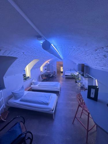 a room with three beds and a table and chairs at Soulfactory Apartments in Neu Ulm