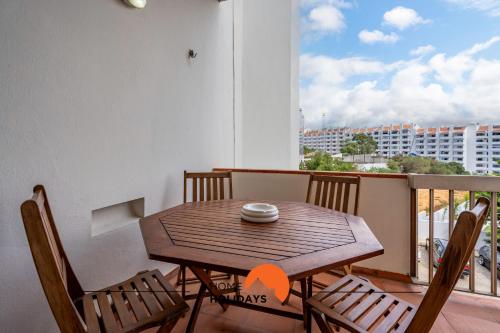 a wooden table and chairs on a balcony at #212 Vila Magna 106B by Home Holidays in Vale de Pedras