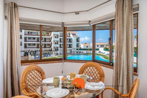 a dining room with a table and chairs and a large window at #212 Vila Magna 106B by Home Holidays in Vale de Pedras