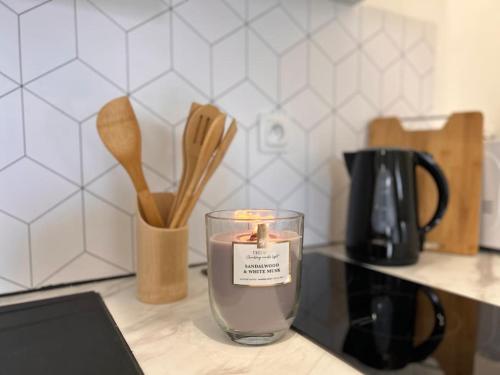 une bougie dans un verre sur un comptoir avec des ustensiles dans l'établissement Studio du Voyageur - Machine à laver - Proche gare, à Sainte-Savine