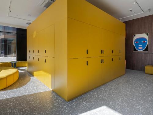 a room with yellow lockers and a yellow wall at Numa Salzburg Vogelweider in Salzburg