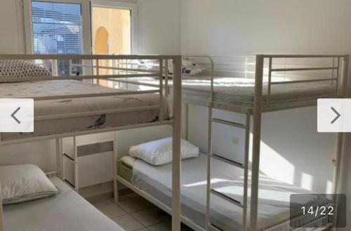 - deux lits superposés dans une petite chambre avec deux flèches dans l'établissement Maison indépendante terasse et jardin, à Nîmes