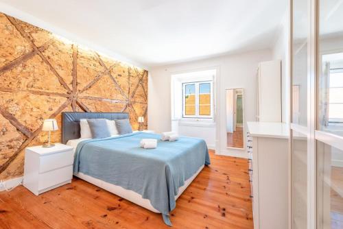 a bedroom with a bed and a large brick wall at GuestReady - Sunshine Belém in Lisbon