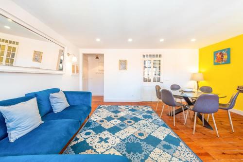 a living room with a blue couch and a table at GuestReady - Sunshine Belém in Lisbon