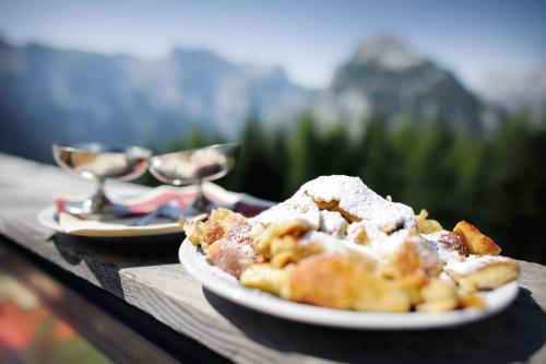a plate of food on a table with two spoons at Das Ferienhaus in Achenkirch in Achenkirch