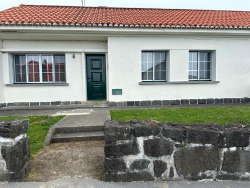 a white house with a green door and windows at Santa Cruz das Flores in Lajes das Flores