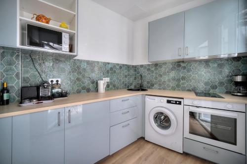 une cuisine avec des armoires blanches et une laveuse et une sécheuse dans l'établissement 2 pieces moderne, quartier du Suquet, A1B261, à Cannes