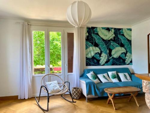 un salon avec un canapé bleu et une fenêtre dans l'établissement La Terrasse du Fourcat, à Saint-Paul-de-Jarrat