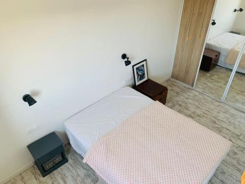 une chambre avec un lit et un miroir dans l'établissement Appartement de 40 m2 à Palavas les Flots, à Palavas-les-Flots