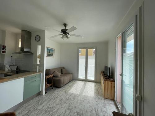 un salon avec un canapé et un ventilateur de plafond dans l'établissement Appartement de 40 m2 à Palavas les Flots, à Palavas-les-Flots