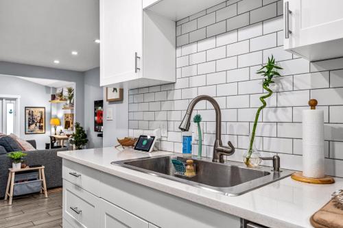 a kitchen with a sink and a living room at Zen Retreat - Sauna Pool Cold Plunge & More in Fort Lauderdale