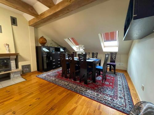 a dining room with a table and chairs on a rug at Apartament Boh. Warszawy 43 D/6 in Szczecinek