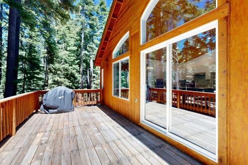 a wooden porch of a cabin with a large window at Tyrol Getaway in Truckee