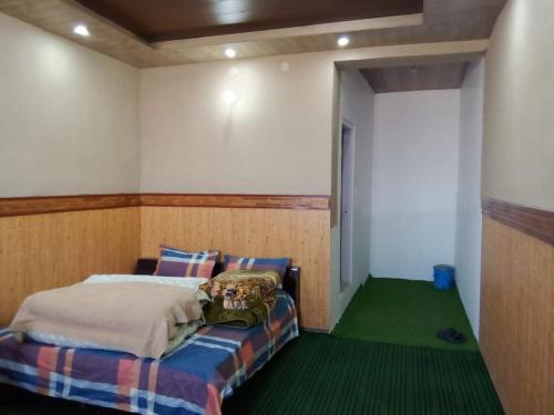 a bedroom with a bed and a green floor at nako valley home stay in Nako