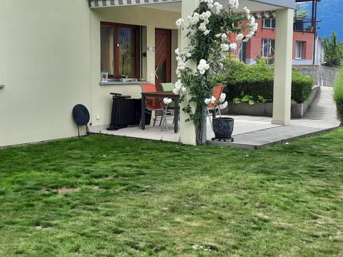 a house with a table and chairs in a yard at Apartment Lakeview La Marea by Interhome in Piazzogna