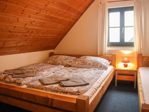 ein Schlafzimmer mit einem Holzbett mit Fenster in der Unterkunft Holiday Home Holiday Hill 41 by Interhome in Černý Důl