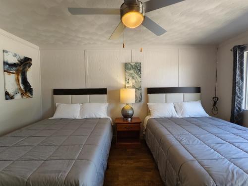 a bedroom with two beds and a ceiling fan at Lake Hudson Inn in Spavinaw