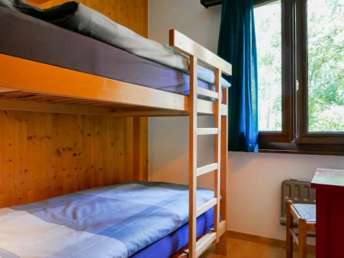 two bunk beds in a room with a window at Holiday Home Chalet Al Portic by Interhome in Scona