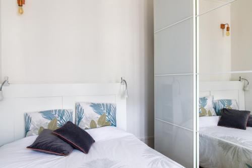 une chambre avec deux lits et un miroir dans l'établissement Radiant 1BD Apart in Clignancourt, à Paris