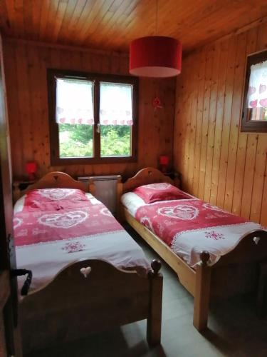 - 2 lits dans une chambre dotée de murs en bois et de fenêtres dans l'établissement appartement sur domaine des Sybelles St Jean d'Arves, à La Chal