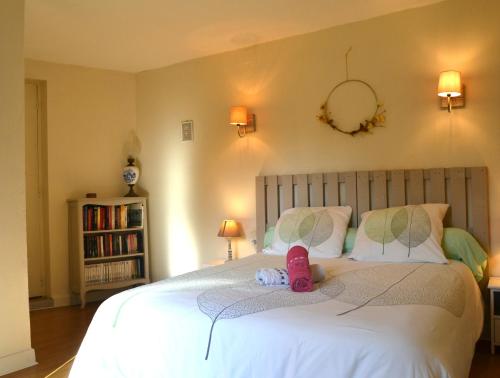 a bedroom with a bed with a stuffed animal on it at Gîte l'ancienne épicerie Meyronne in Meyronne